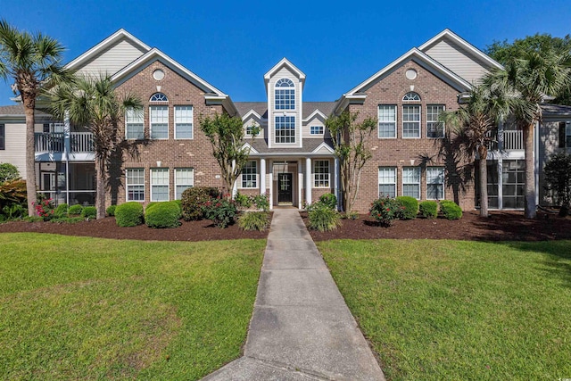 view of front of home with a front lawn and brick siding