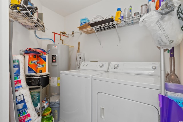 clothes washing area with separate washer and dryer, water heater, and laundry area