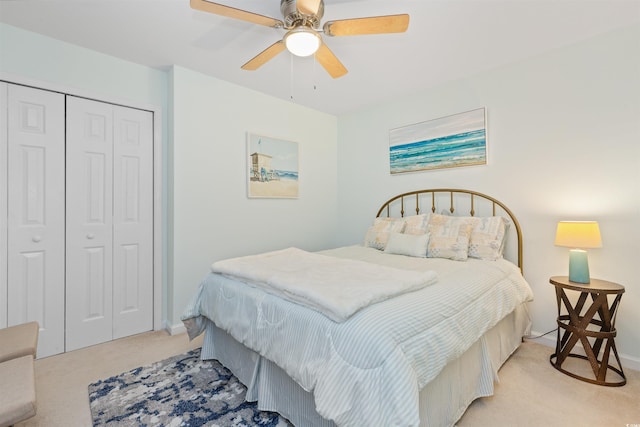 bedroom featuring light colored carpet, a closet, baseboards, and ceiling fan