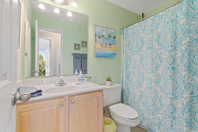 full bathroom with toilet, vanity, and curtained shower