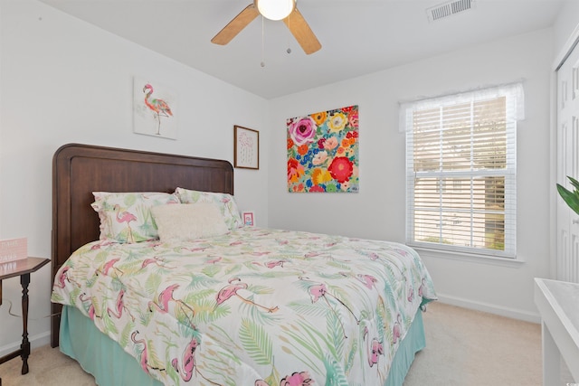 bedroom with visible vents, baseboards, a ceiling fan, and light carpet