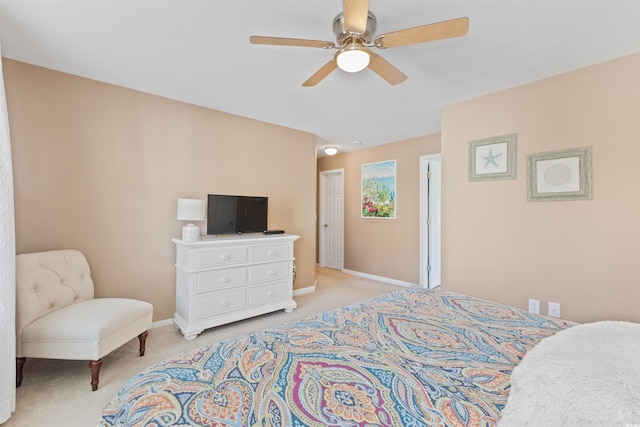 bedroom featuring light colored carpet, baseboards, and a ceiling fan