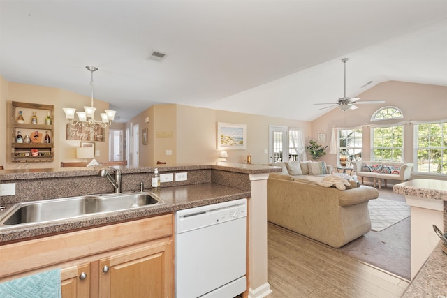 kitchen with white dishwasher, light brown cabinets, visible vents, a sink, and vaulted ceiling