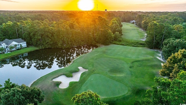 birds eye view of property featuring a wooded view, view of golf course, and a water view
