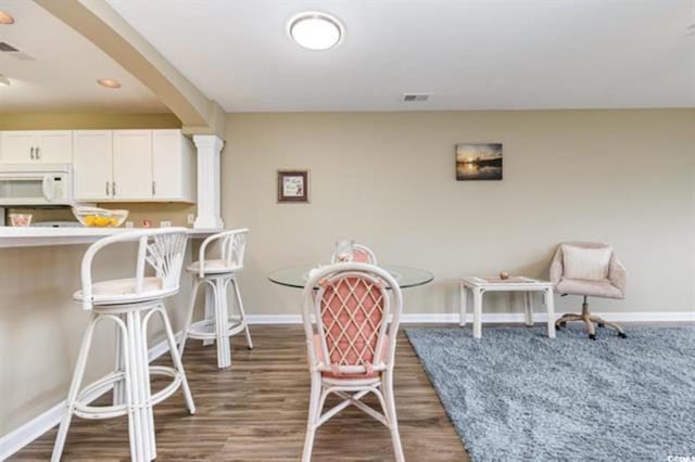 interior space featuring baseboards, wood finished floors, and white microwave