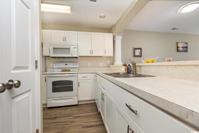 kitchen featuring dark wood finished floors, white cabinetry, ornate columns, white appliances, and light countertops