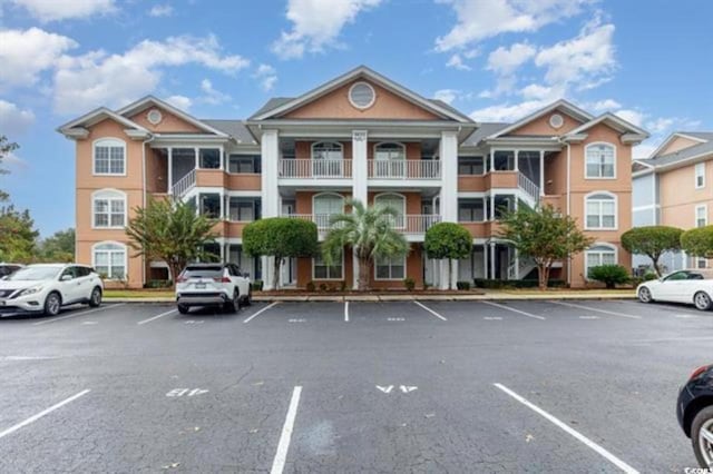 view of building exterior with uncovered parking