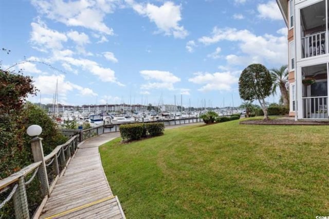 surrounding community featuring a lawn and a water view
