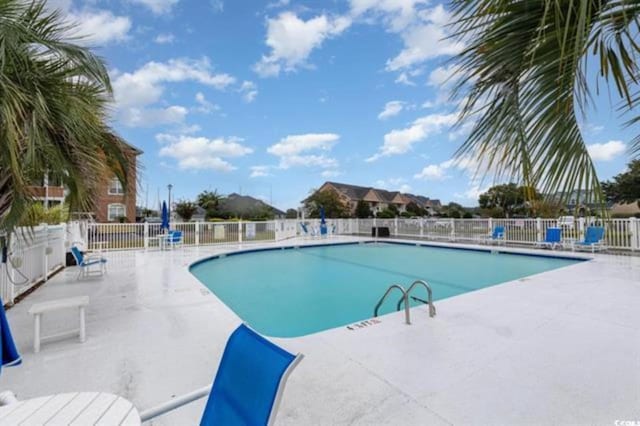 community pool featuring fence and a patio