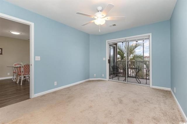 carpeted spare room with ceiling fan, baseboards, and visible vents