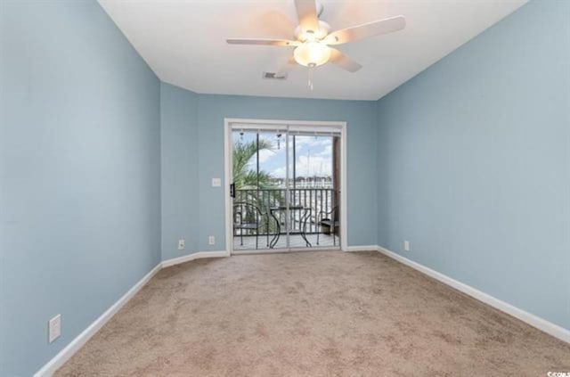 spare room featuring ceiling fan, carpet floors, visible vents, and baseboards