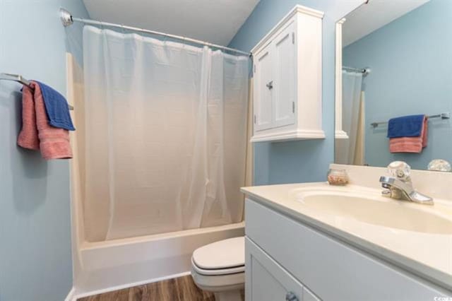 bathroom with wood finished floors, vanity, shower / bathtub combination with curtain, and toilet