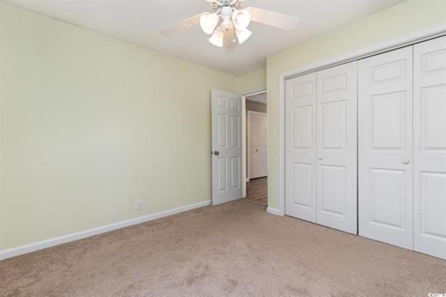 unfurnished bedroom featuring light colored carpet, ceiling fan, baseboards, and a closet