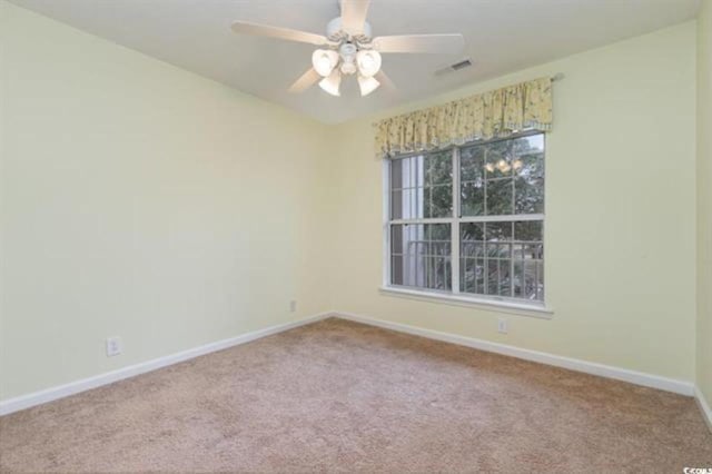 unfurnished room featuring baseboards, visible vents, carpet floors, and ceiling fan