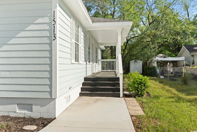 doorway to property with a yard, a porch, fence, and crawl space