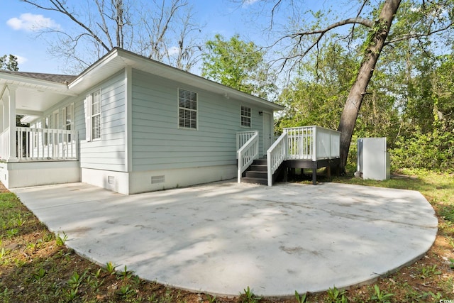 rear view of house featuring a patio area, crawl space, and a porch