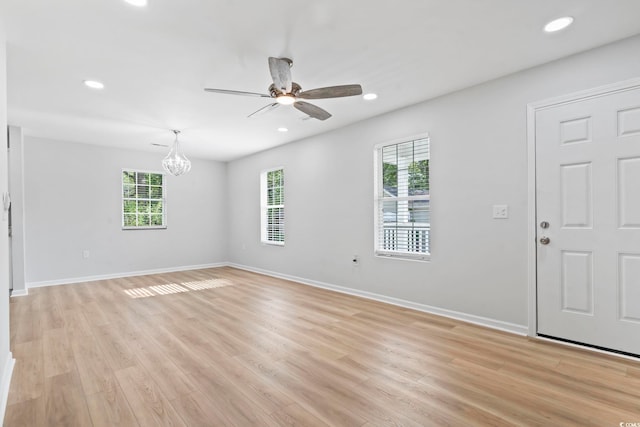 interior space featuring baseboards, a wealth of natural light, recessed lighting, and ceiling fan with notable chandelier