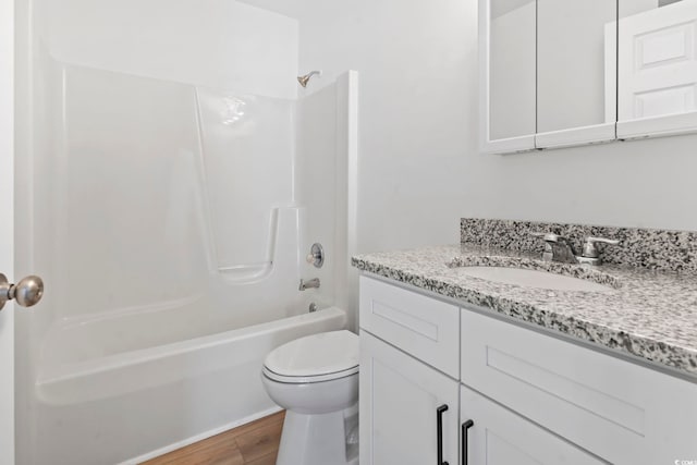 full bath with vanity, toilet, wood finished floors, and shower / tub combination