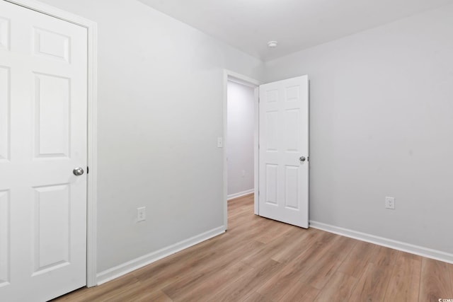 unfurnished bedroom with light wood-style flooring and baseboards