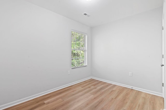 spare room with light wood-style flooring, baseboards, and visible vents