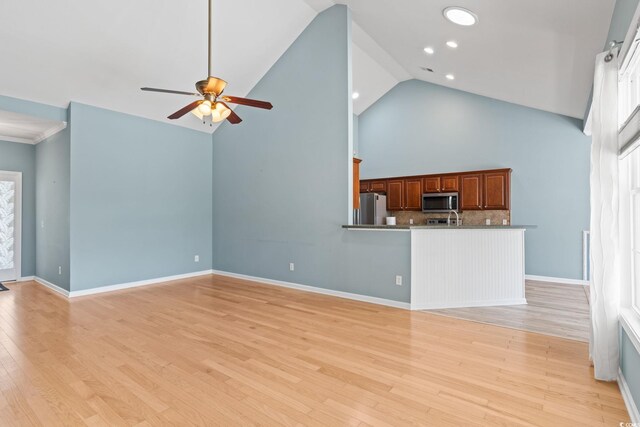 unfurnished living room with ceiling fan, high vaulted ceiling, light wood-style floors, recessed lighting, and baseboards