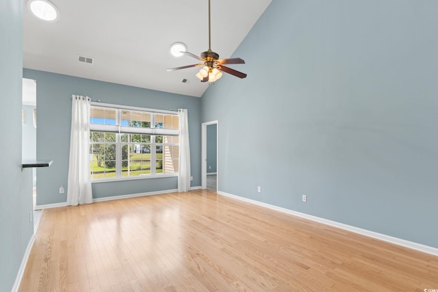 unfurnished room with light wood-style floors, ceiling fan, baseboards, and high vaulted ceiling