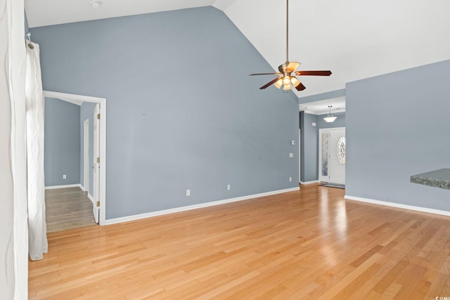 unfurnished living room featuring high vaulted ceiling, ceiling fan, light wood finished floors, and baseboards