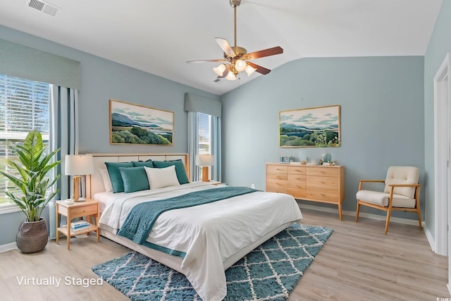 bedroom featuring light wood-style flooring, vaulted ceiling, baseboards, and ceiling fan