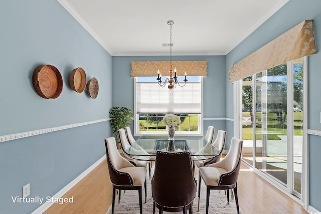 dining area with wood finished floors, a chandelier, ornamental molding, and baseboards