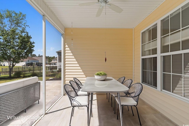 sunroom featuring a ceiling fan and outdoor dining space