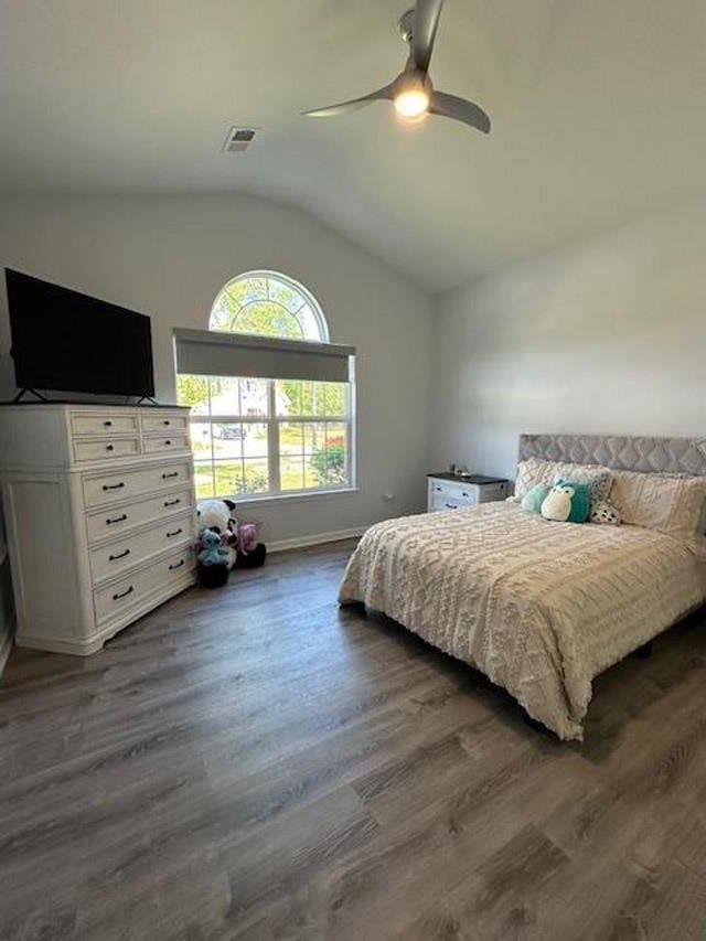 bedroom featuring lofted ceiling, visible vents, a ceiling fan, and dark wood-style floors