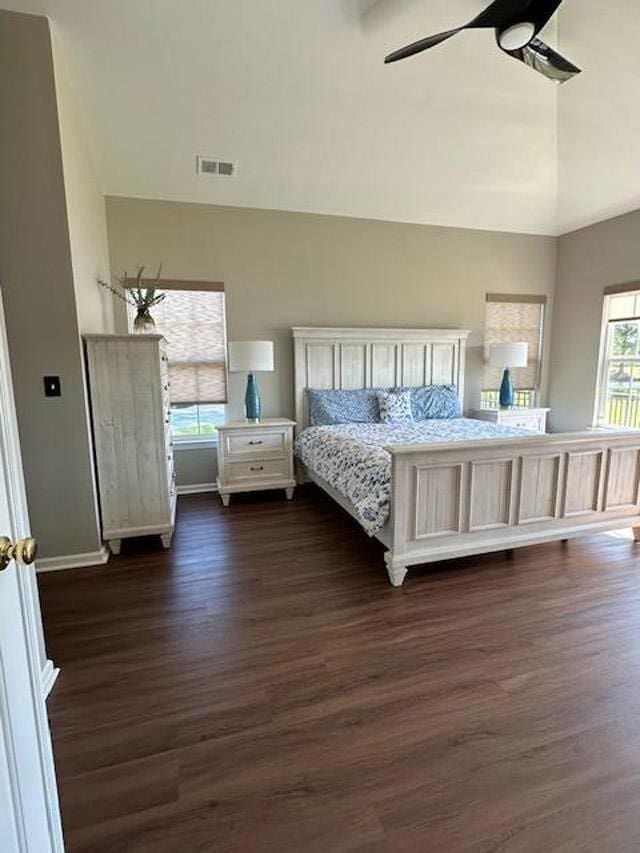 bedroom with dark wood finished floors, vaulted ceiling, visible vents, a ceiling fan, and baseboards