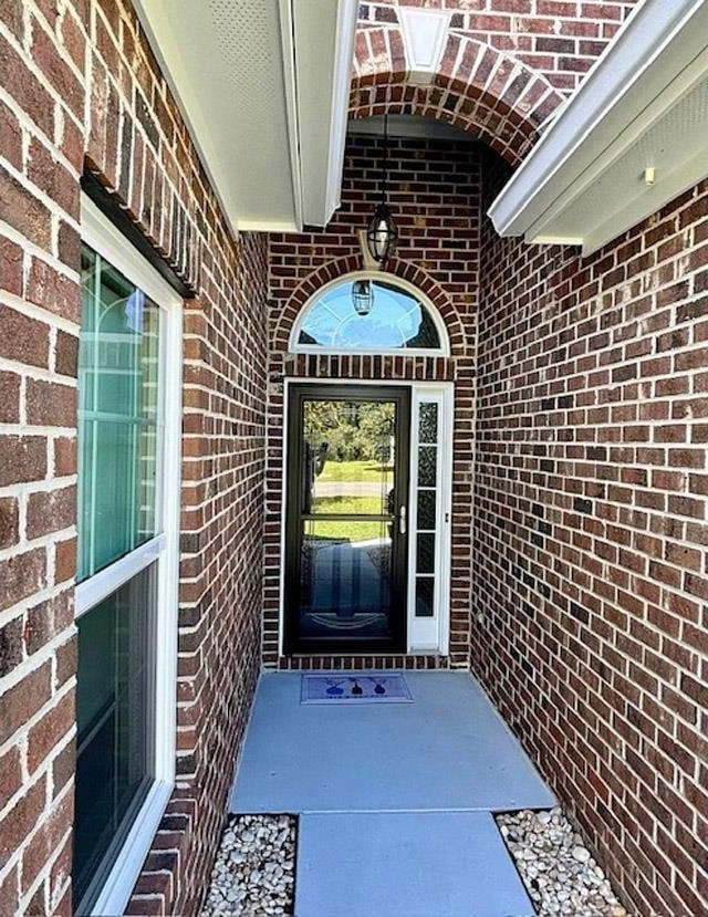 doorway to property with brick siding