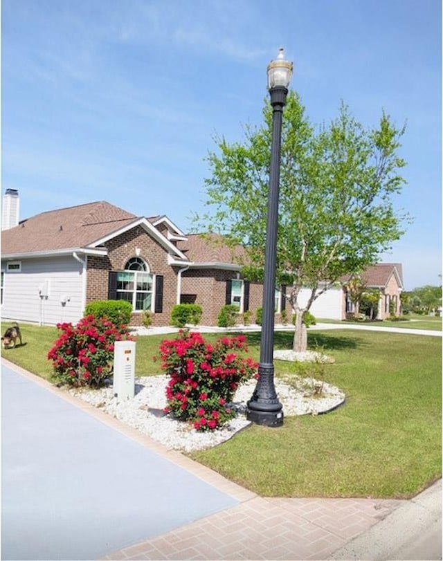 ranch-style house featuring brick siding and a front lawn