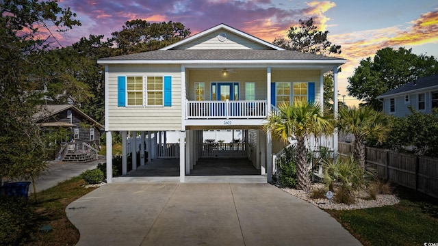 2602 Holly Dr, North Myrtle Beach, SC 29582 - beach home with a carport, driveway, a shingled roof, and covered porch