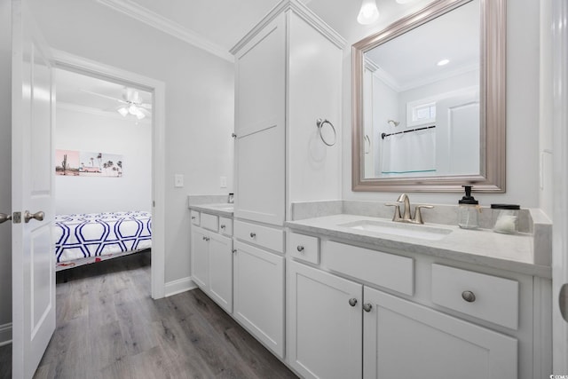 2602 Holly Dr, North Myrtle Beach, SC 29582 - bathroom with crown molding, double vanity, wood finished floors, connected bathroom, and baseboards