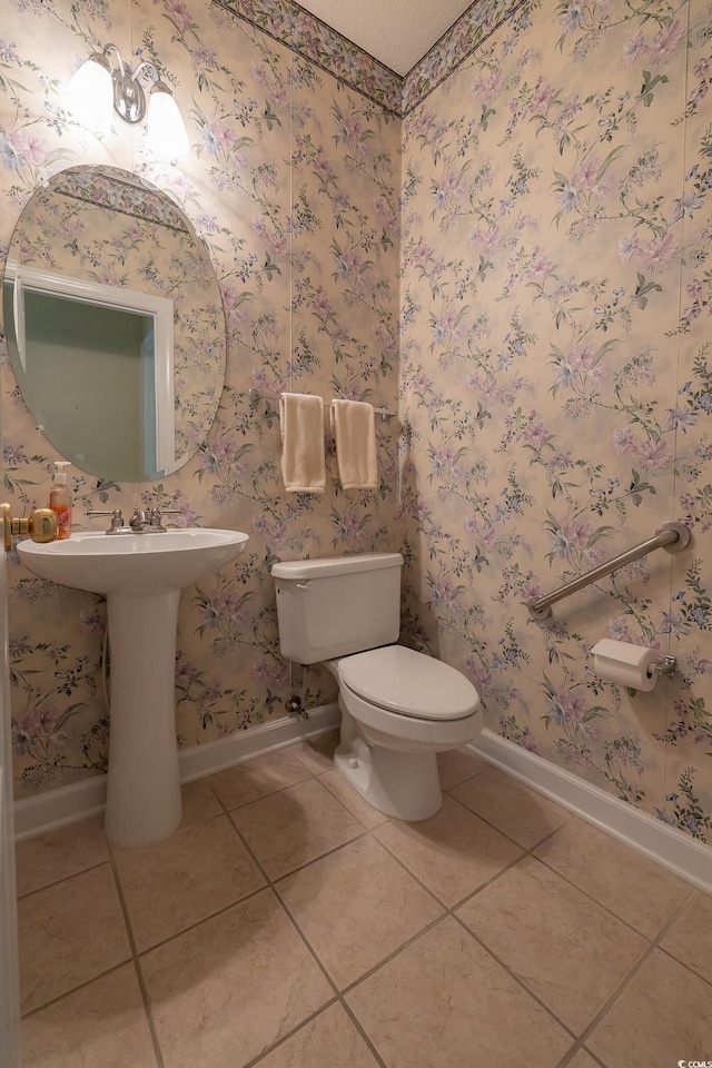 half bathroom featuring tile patterned flooring, baseboards, and toilet