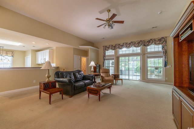living room featuring a ceiling fan, baseboards, and light colored carpet