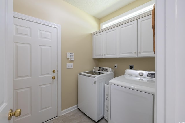 laundry room with separate washer and dryer, baseboards, cabinet space, and light tile patterned flooring