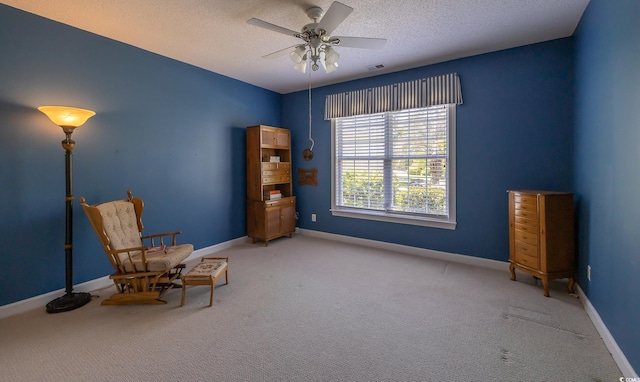 sitting room with carpet flooring, a textured ceiling, baseboards, visible vents, and ceiling fan