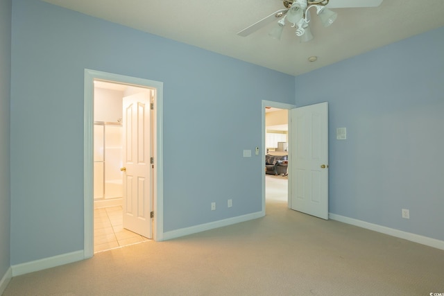 unfurnished bedroom with ceiling fan, baseboards, ensuite bathroom, and carpet