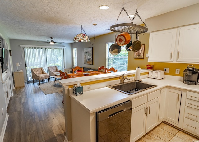 227 Pinehurst Ln Unit 6D, Pawleys Island, SC 29585 - kitchen featuring light countertops, dishwasher, a sink, a peninsula, and a textured ceiling