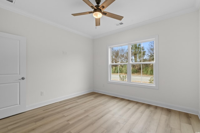 empty room featuring ornamental molding, a ceiling fan, light wood finished floors, and baseboards