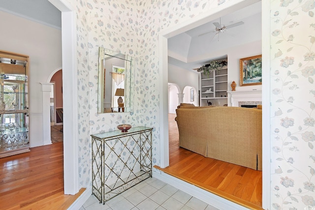 321 Heather Ct, Sunset Beach, NC 28468 - hallway with arched walkways, wood finished floors, wallpapered walls, baseboards, and crown molding