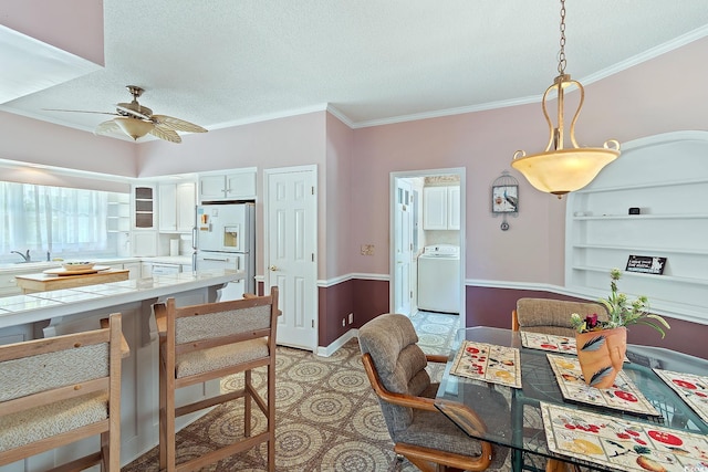 321 Heather Ct, Sunset Beach, NC 28468 - dining space featuring a textured ceiling, washer / dryer, a ceiling fan, and crown molding