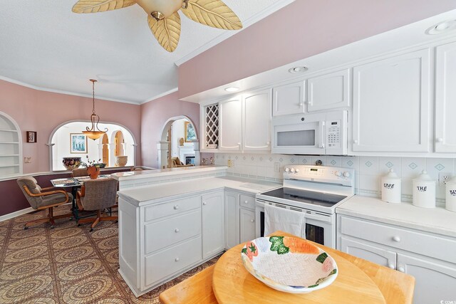 321 Heather Ct, Sunset Beach, NC 28468 - kitchen with white appliances, crown molding, white cabinets, and light countertops