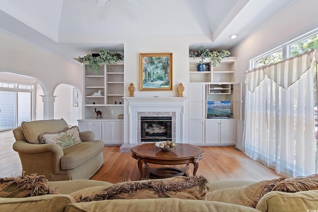 321 Heather Ct, Sunset Beach, NC 28468 - living room with high vaulted ceiling, arched walkways, a high end fireplace, and light wood-style floors