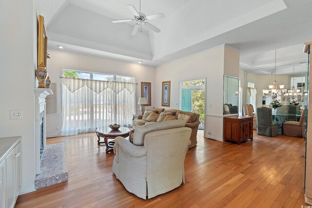 321 Heather Ct, Sunset Beach, NC 28468 - living room with a tray ceiling, light wood-style floors, and ceiling fan with notable chandelier