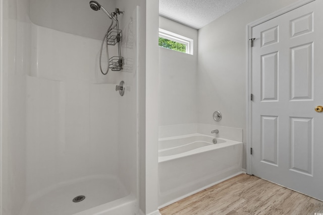 622 Oakhurst Dr, Myrtle Beach, SC 29579 - bathroom with wood finished floors, a textured ceiling, a shower, and a bath