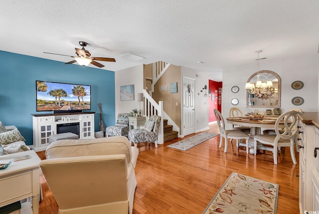 1046 Palisade Cir Unit 1046, Myrtle Beach, SC 29577 - living area with stairway, a textured ceiling, light wood-style floors, a chandelier, and a ceiling fan